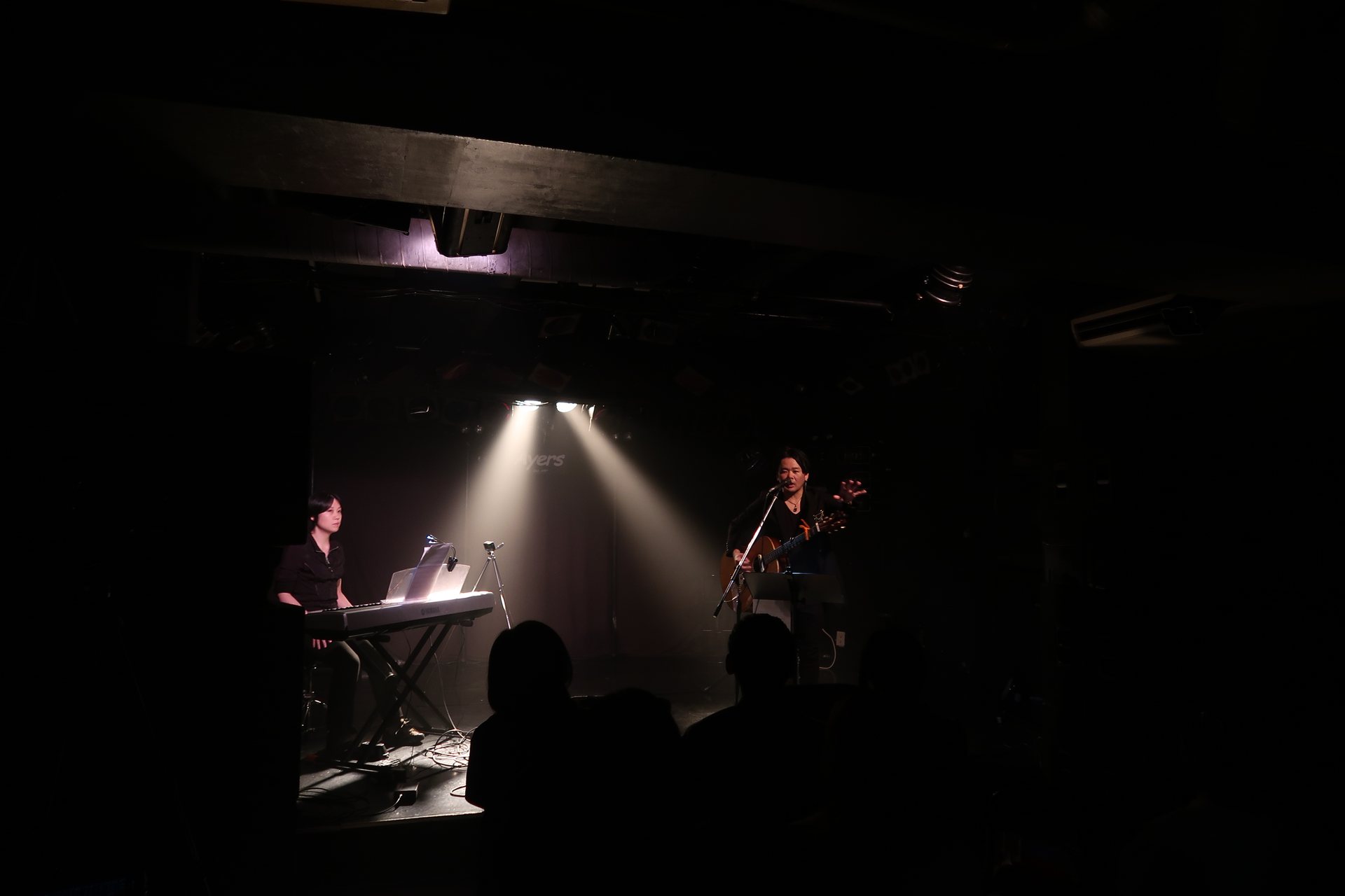 憲史の歌に耳を傾けるライブ会場の観客